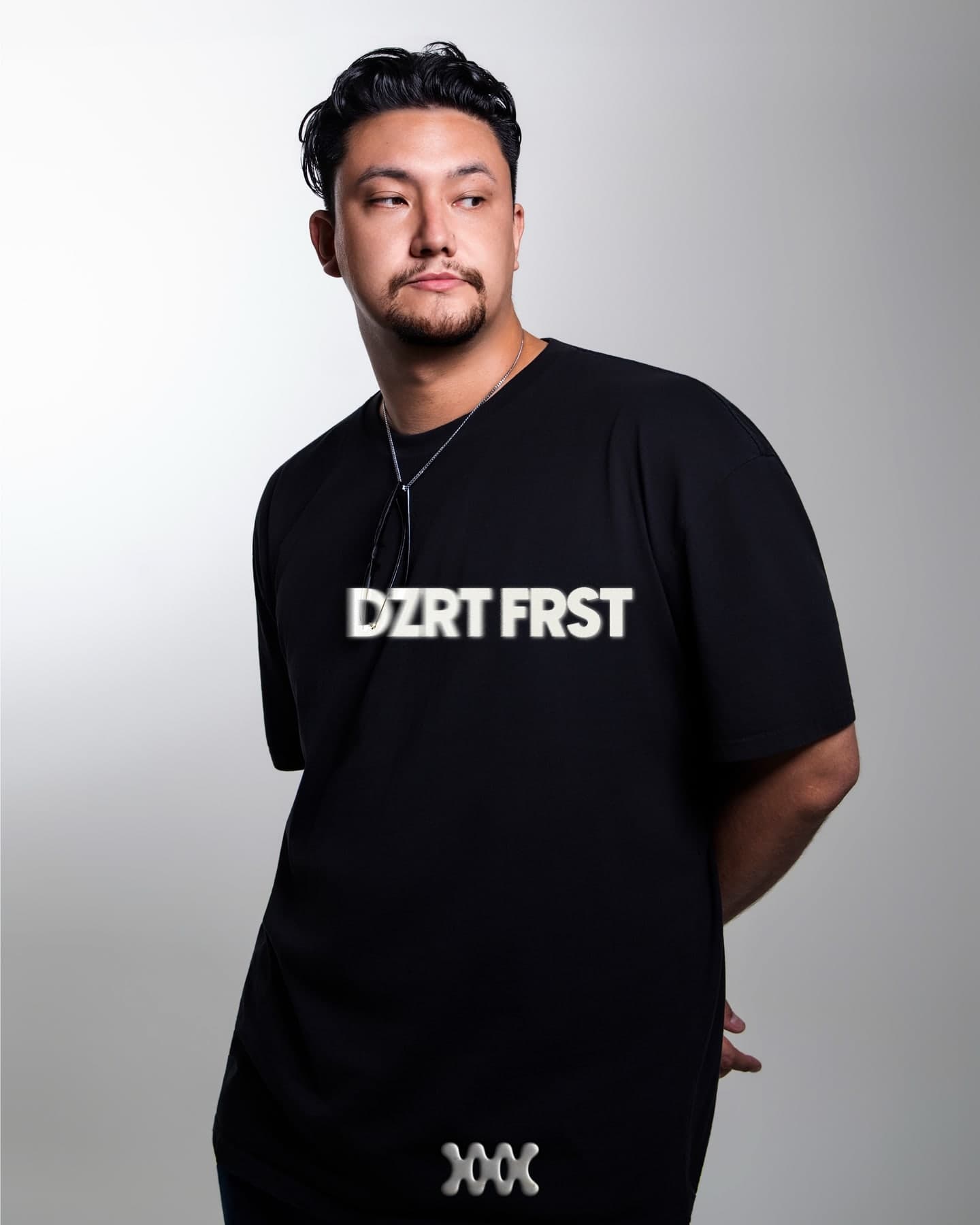 Retrato de estudio de DZRT FRST sobre gris, con el nombre sobre el pecho